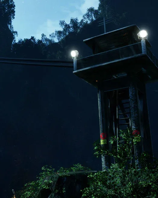 A floodlit watchtower in the hills at night